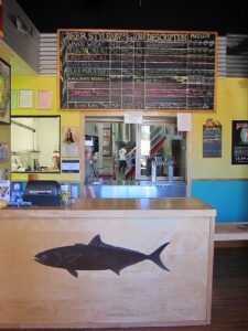 The tasting room at Ballast Point Brewing Company with the beer menu board