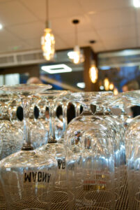 Empty beer glasses lined up on a bar under warm lighting